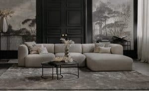 Element sofa Emanuelle with a longchair. Made from a light beige fabric. Combined with a large rug and natural decoration.