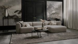Element sofa Emanuelle with a longchair. Made from a light beige fabric. Combined with a large rug and natural decoration.