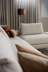 Beiges Sofa mit verschiedenen Elementen und ansprechendem rot/pinkem Innendesign.