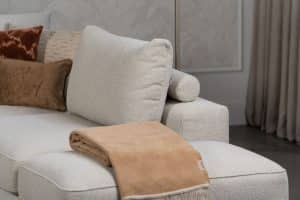 Beiges Sofa mit verschiedenen Elementen und ansprechendem rot/pinkem Innendesign.