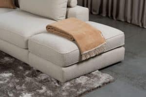 Beiges Sofa mit verschiedenen Elementen und ansprechendem rot/pinkem Innendesign.