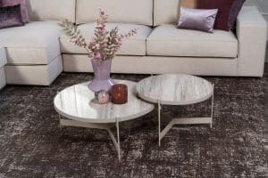 Beige hoekbank met grote hoek, gestyled met woonaccessoires in Burgundy.