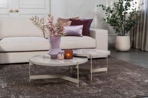 Beige hoekbank met grote hoek, gestyled met woonaccessoires in Burgundy.