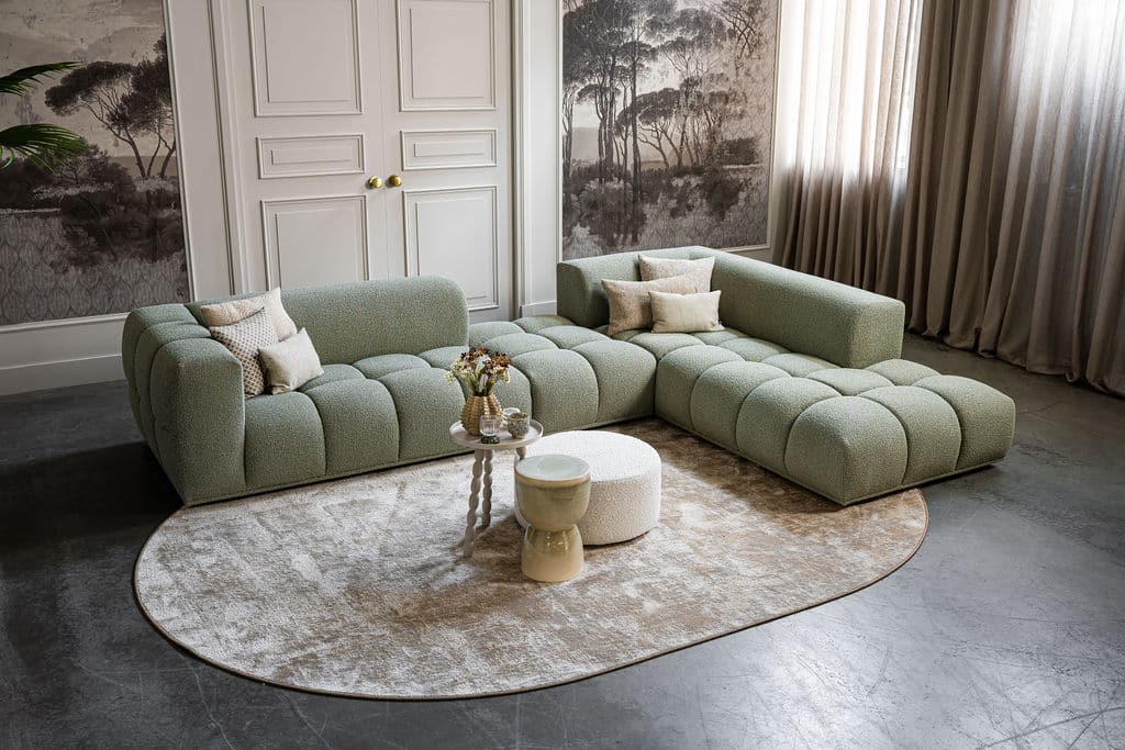 Groene hoekbank met de perfecte accessoires, sierkussens en vloerkleed.