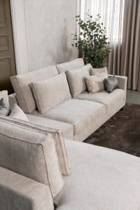 Hoekbank Gigi in een neutrale beige kleur, gestyled met accessoires in warme aardetinten.