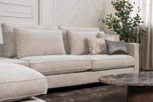 Hoekbank Gigi in een neutrale beige kleur, gestyled met accessoires in warme aardetinten.