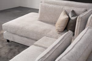 Hoekbank Gigi in een neutrale beige kleur, gestyled met accessoires in warme aardetinten.